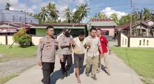Pelaku AP saat di giring oleh anggota Polsek Jawai